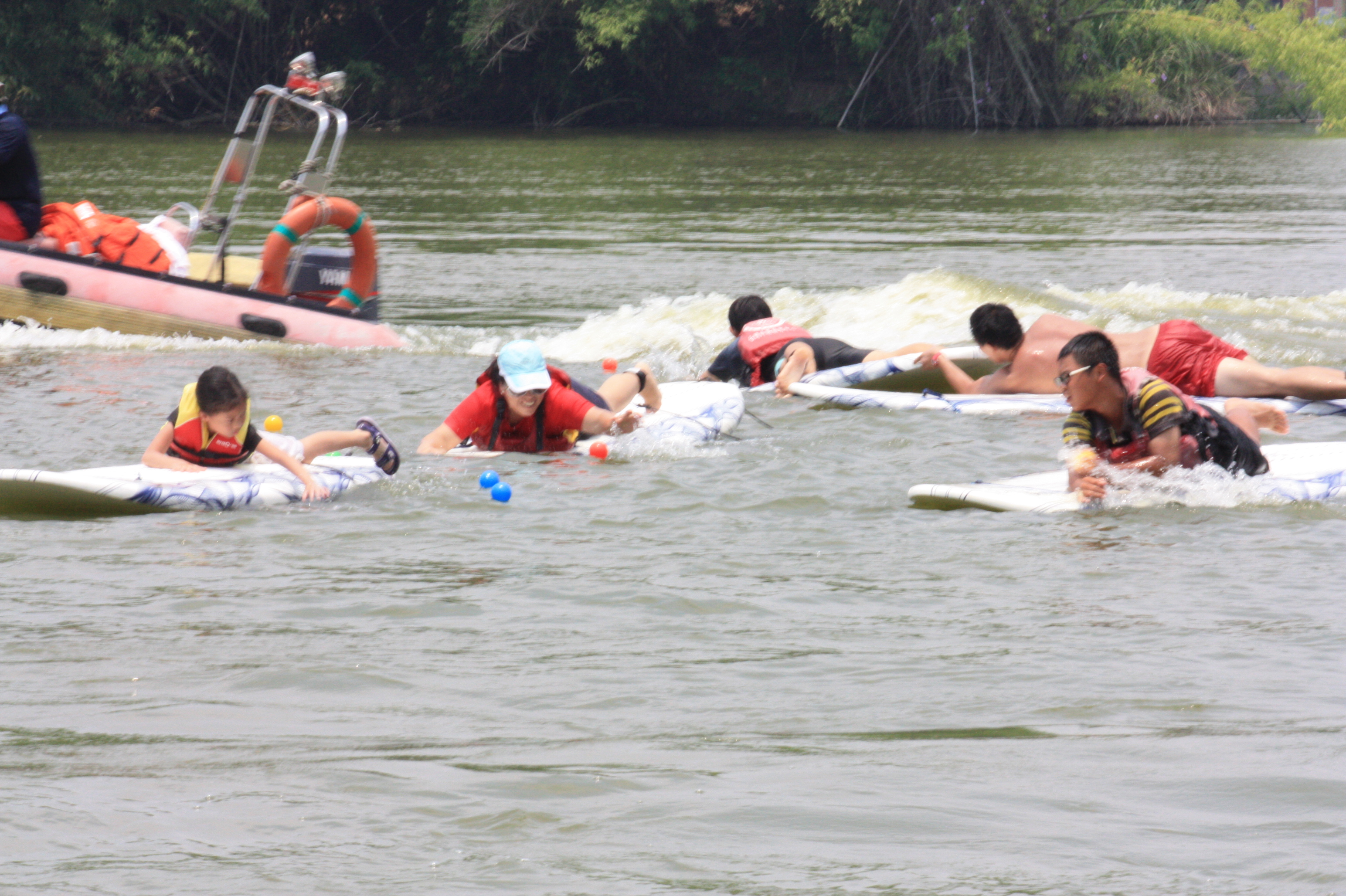 比賽開始，選手們穿上救生衣，踏上划浪板，在湖面上用盡各種方法讓自己的划浪板超越對手